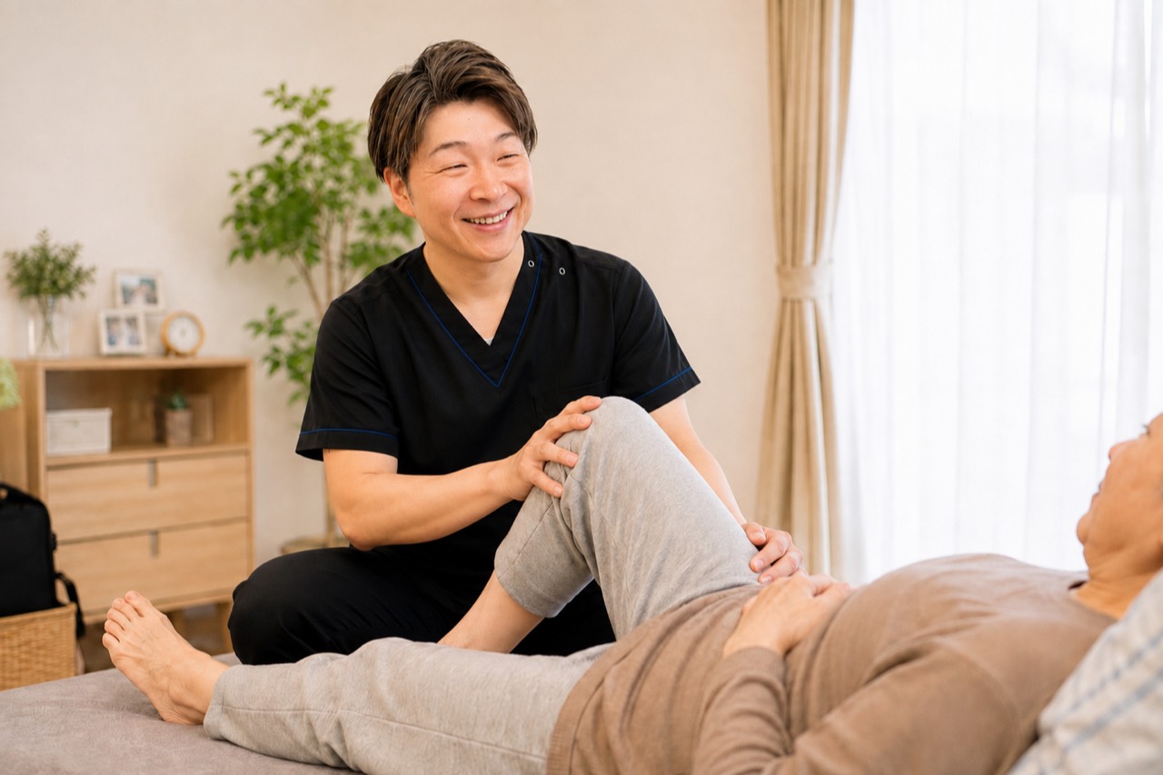 ご自宅で横になる利用者の膝を施術する訪問施術者